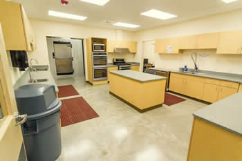 Kitchen with sink, ovens and fridge